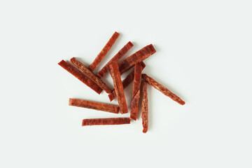 Dried jerky pieces of fish meat red heap. White background.