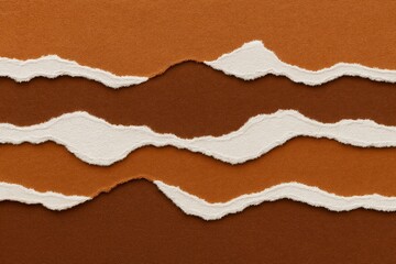 Abstract layered background made of torn brown cardboard paper with soft textured edges. Concept of artistic creativity, eco-friendly packaging, and visual communication design.