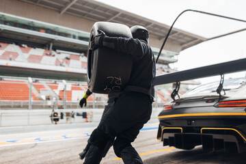 Team Mechanics Changing Tires During a High-Speed Pit Stop in the Midst of an Endurance Race
