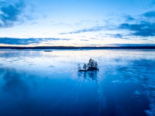 Frozen lake with island at sunset.