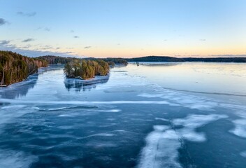 Frozen lake with islands at sunset