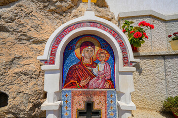Wall fountain with mosaics of the Virgin Mary and Jesus Christ outside of the Ostrog Monastery of...