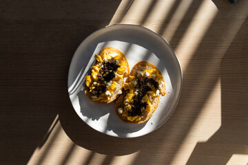 Two slices of bread with scrambled eggs, feta cheese, and truffle paste.