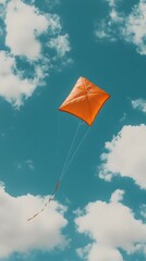 Orange kite soaring high in a vibrant blue sky filled with fluffy white clouds. A perfect image for freedom, joy, and childhood memories.