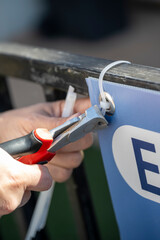 mains d'une femme installant un panneau avec des rilsans et une pince coupante
