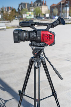 camera panasonic noire et rouge sur tr&eacute;pied en ext&eacute;rieur, gros camescope