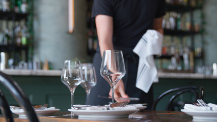 Close Up Of Male Server Laying Place Setting On Restaurant Table