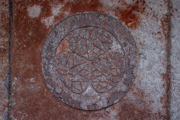 Close-up of an ancient engraved emblem on a weathered stone surface at Toshogu Shrine in Nikko Japan featuring intricate geometric patterns with visible patina