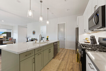 A beautiful kitchen featuring a large island, stove, microwave, and sink