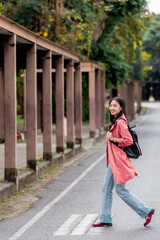 Young student walking on pedestrian crossing near university campus
