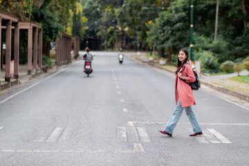 Fototapeta premium Young student crossing the road on pedestrian crossing