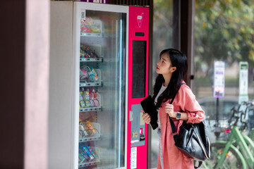 Young student choosing snacks and drinks at vending machine