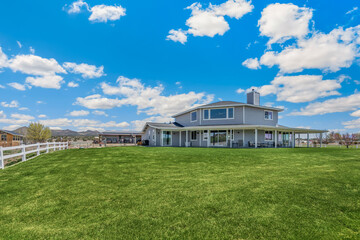 A large house with a lawn and a white fence in front