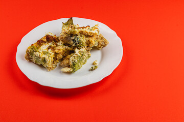 Savory casserole with egg, broccoli, and chicken fillet on a bright plate