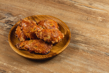 Deliciously baked pumpkin wings served on a rustic wooden plate