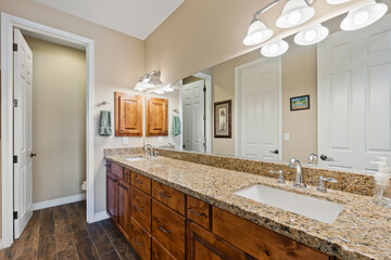 A spacious bathroom featuring two sinks and a large wall mirror