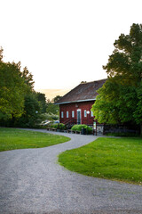 Scenic Park Path Leading to a Red Wooden House at Sunset, Stockholm