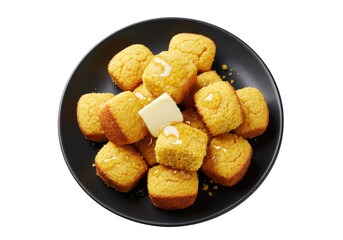 Freshly baked cornbread squares drizzled with honey on a black plate