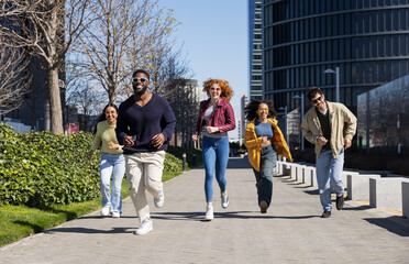 Obraz premium Group of diverse friends playfully running together in the city