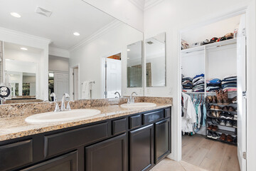 A spacious bathroom that features two sinks along with a walkin closet