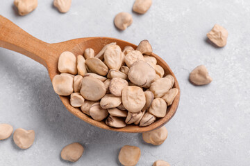 Organic raw dry Grass pea close up on wooden spoon. Healthy, protein source for vegan and vegetarian diet. Traditional Italian apulian cuisine ingredient. Legumes known as Cicerchia, Vetch, Indian Pea