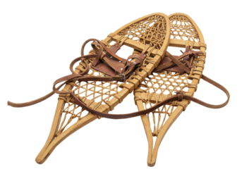 Vintage wooden snowshoes with leather straps resting on a white background