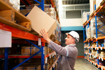 A warehouse worker organizes boxes on high shelves, showcasing efficiency and safety in logistics operations.