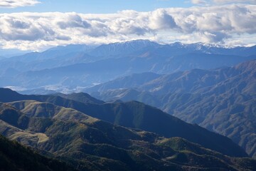 Fototapeta premium Mountain range view with blue skies and clouds above peaks