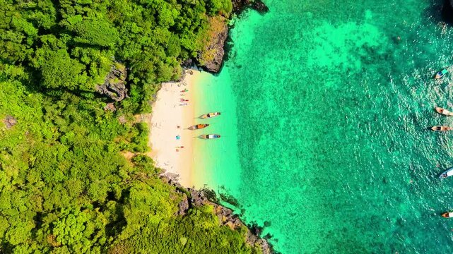 Aerial drone distancing view landscape bay turquoise lagoon Nui beach with long tail boat koh Phi Phi Don island Krabi Thailand