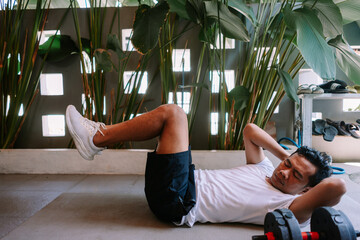Dedicated man doing crunches with a relaxed workout at home yard