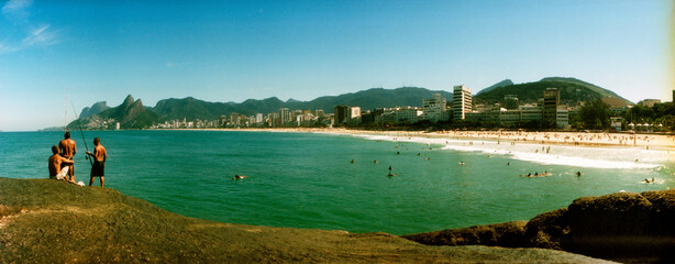 Three men fishing on the beach, Ipanema beach, Rio de Janeiro, Brazil.