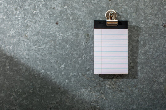 Blank white lined pad of paper on magnet board