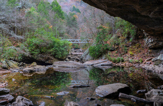 A metal bridge reflected in  North Chickamauga Creek Gorge is part of the Cumberland Trail in Tennessee.  View from an alcove at the creek crossing. 