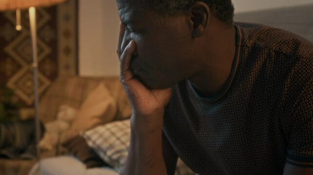 Tilt-up shot of middle-aged African American man feeling anxious about his past due bills and eviction notice