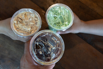 Party ice cool drink.Top view hand holding black coffee, espresso and matcha green tea at coffee shop.Friends having a coffee menu and talking at a cafe.
