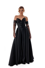Naklejka premium Fashion model showcases elegant black evening gown with sequins at a studio setting during a photoshoot