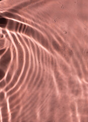 Mediterranean pink terracotta color plaster background with under water sun shadows. 