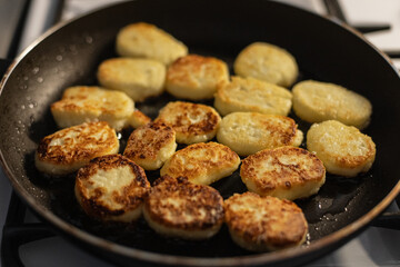 Curd cottage cheese pancakes are fried in a frying pan with oil. Cooking and lessons, concept. Burnt food dessert for breakfast