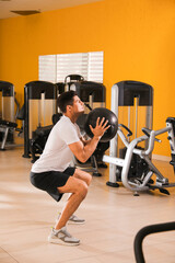 Muscular man exercising with medicine ball in gym