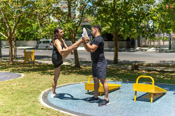 Athletic men doing stretching exercise, preparing for workout in a park