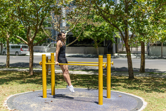 Sporty young man exercising on the parallel bars