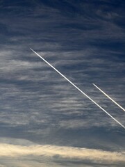 Airplane contrails in the sky above clouds
