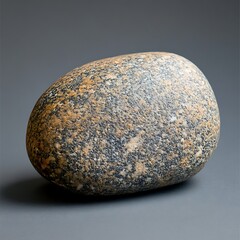 A Smooth Rock Displaying Diverse Colors On A Light Grey Background