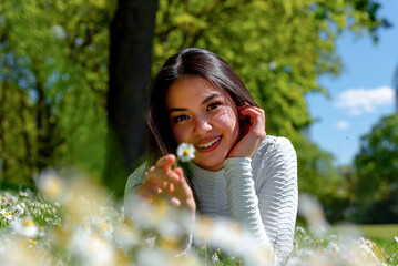 Happy woman portrait surrounded by daisies in a public park in Stuttgart, Germany
