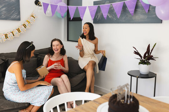 Celebrating birthday, diverse female friends laughing and enjoying party at home