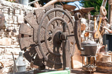 Traditional Cypriot wooden spinning wheel with carvings displayed among vintage items showcasing craftsmanship and history