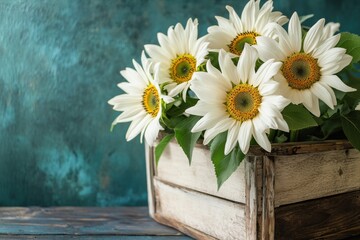 Obraz premium Bright sunflowers in a rustic wooden box against a vibrant turquoise backdrop create a cheerful summer atmosphere
