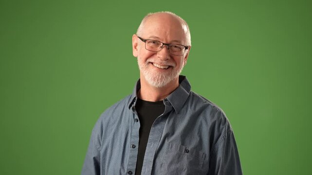 A mature man with a joyful expression holds sheets of paper, gesturing animatedly against a solid green background. His smile reflects excitement and positivity.