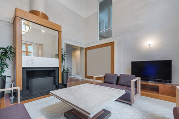 The modern interior of the living room of a country house. Fireplace with exclusive design, stylish decor.