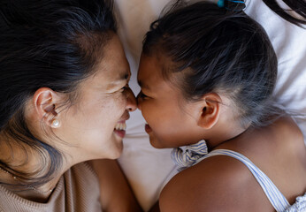 Mother and daughter smiling and bonding closely, enjoying quality time together